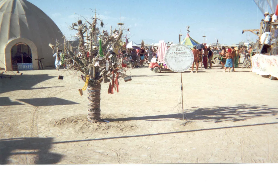 An eight-foot tree sculpture made of scrap wire at Burning Man, its branches hung with objects left by strangers.